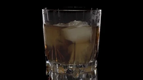 Ice cubes rotating and melts in a glass of whiskey. Isolated on white backgro Stock-Footage 125402282