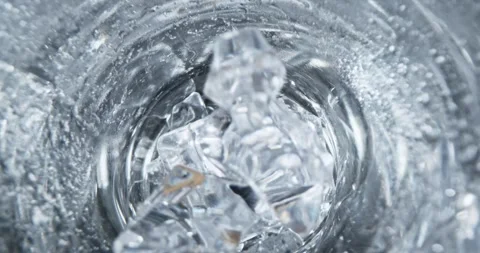 Ice cubes rotating in a glass with crystal clear water. 動画素材 246147848