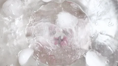 Ice cubes splashing in crystal-clear water create a refreshing frozen texture. P Vídeos de archivo 332850792