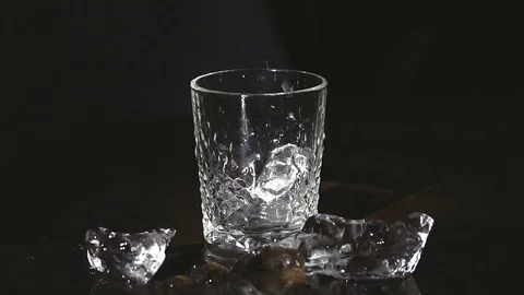 Ice cubes splashing into water over white Stock Footage 83784773
