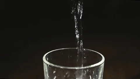 Ice cubes splashing into water over white Stock Footage 83784922