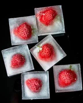 Ice cubes with strawberries. Stock Photos
