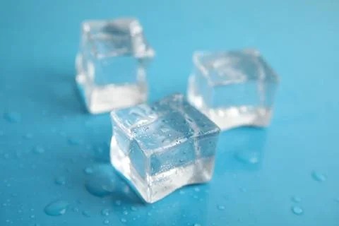 Ice cubes with water drops on light blue background, closeup 写真素材
