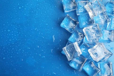 Ice cubes with water drops on light blue background, flat lay. Space for text Foto stock
