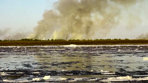 Ice drift on the big river and forest fire Stock Footage 106664927