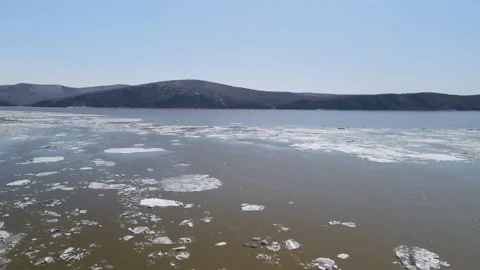 Ice Drift Occurs on River next to the Mountains Ridge cover Forest Stock Footage 194344060