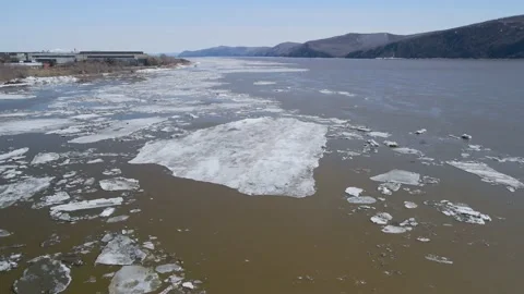 Ice Drift Occurs on the River next to the Mountains Ridge cover Forest in Spring Stock Footage 194344203