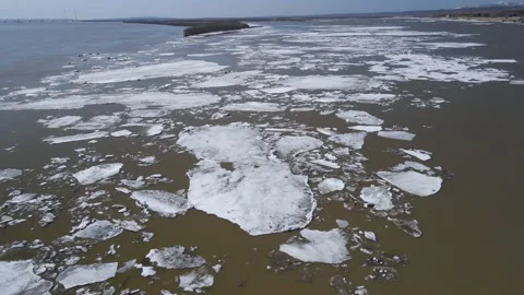 Ice Drift Occurs on River next to a Island with Forest, Aerial view Stock Footage 194344246