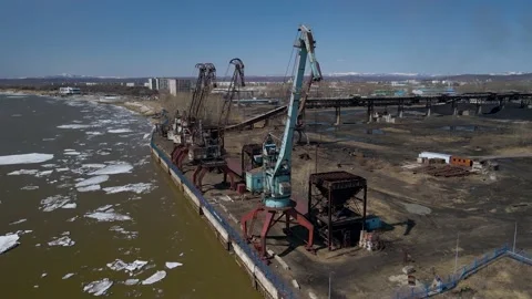 Ice Drift Occurs on the River next to a Port with Big Cranes and Factory Stock Footage 194344637