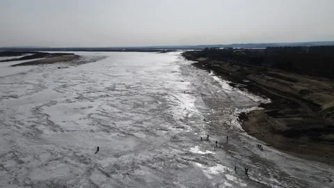 Ice Drift Occurs on River next to Mountains Ridges and Village on a Island Stock Footage 194347671
