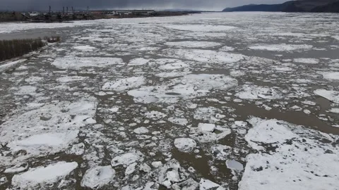 Ice Drift Occurs on the River next to the Island with Forest and Mountains Ridge Stock Footage 194347757