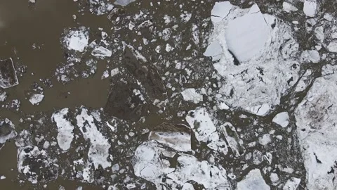 Ice Drift Occurs on a River next to a Island with Forest, Aerial view above Stock Footage 194347763