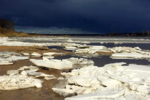 Ice drift on the river. End of winter. Huge white ice floes crack.Spring is c Stock Photos