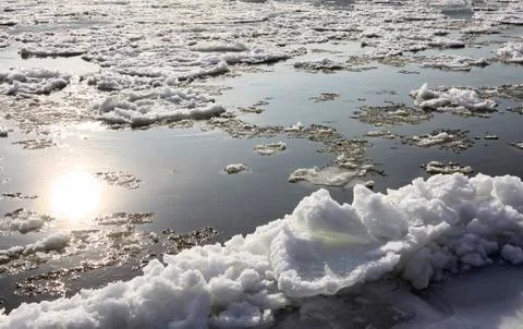 Ice drift on the river. Reflection of the sun in autumn water. Stock-Fotos