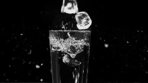 Ice dropped into glass in super slow motion. Shot with cinema camera RED DRAGON Video stock 123711646