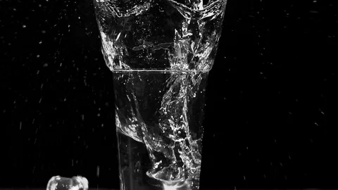 Ice dropped into glass in super slow motion. Shot with cinema camera RED DRAGON Video stock 123711764