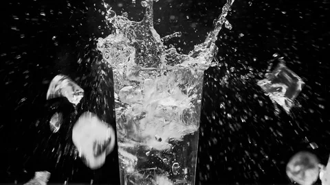 Ice dropped into glass in super slow motion. Shot with cinema camera RED DRAGON Video stock 123711821