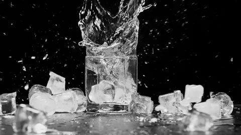 Ice dropped into glass in super slow motion. Shot with cinema camera RED DRAGON Vídeo Stock 123712040