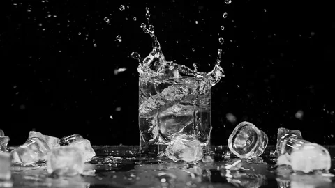 Ice dropped into glass in super slow motion. Shot with cinema camera RED DRAGON Video stock 123712120