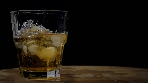Ice float in a glass of whiskey in slow motion Stock Footage 120929293