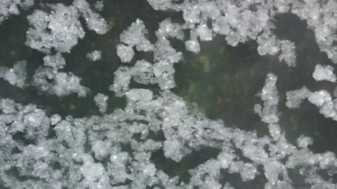 Ice floating by in a river with clear water from above Stock Footage 310572203