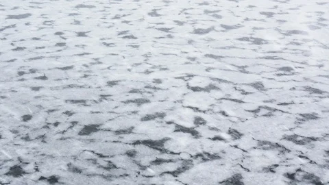 Ice floating on the surface of a semi-frozen lake during a snow storm Stock Footage 113229503