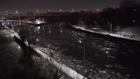 Ice floe shards swimming on canal river at night in Berlin Siemensstadt Stock Footage