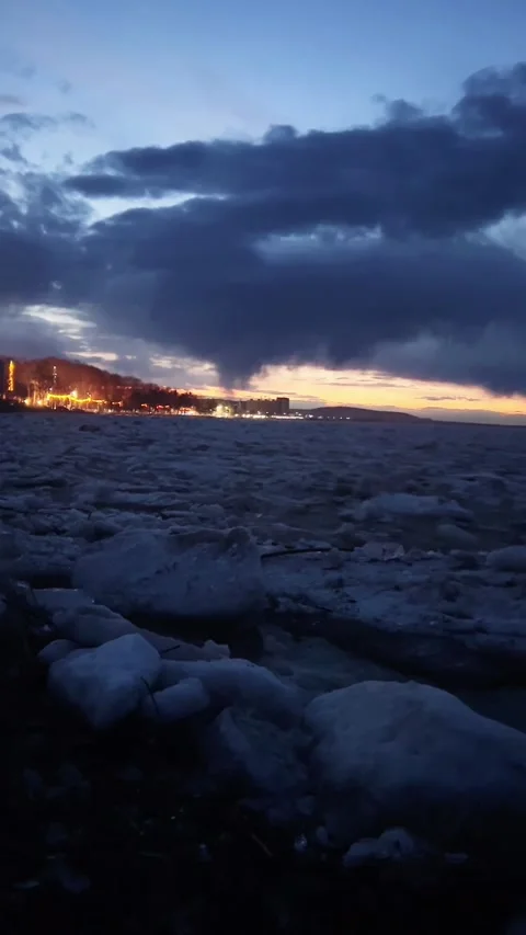 Ice Floes Breaking Up on a River with Cityscape at Dusk, Northeast China Stock Footage 337331025