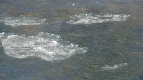 Ice floes float in a clear mountain river. Ice floats down a mountain river. The Stock Footage 263149207