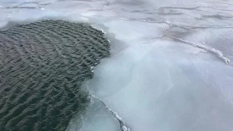 Ice floes float in cold water giving natural cracked ice texture with sun ref Stock Photos