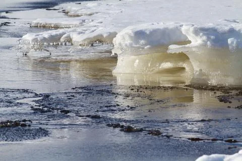 Ice floes float past the blurred edge of the shore ice Stock Photos