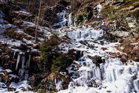 Ice formations along the mountain side on a river valley Foto stock