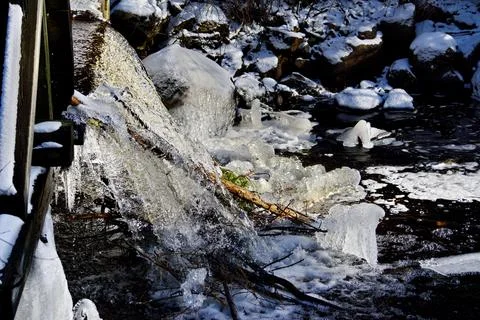Ice forms in winter along a water sluice Stock Photos