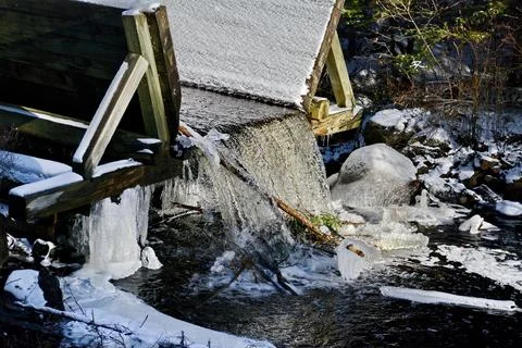 Ice forms in winter along a water sluice Stock Photos