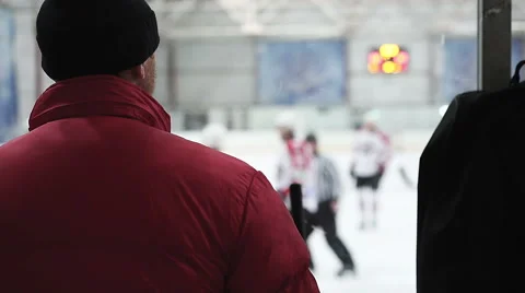 Ice hockey coach watching as match between rival teams begins, referees on rink Stock Footage