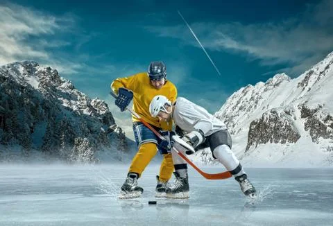 Ice hockey player in action outdoor around mountains Stock Photos