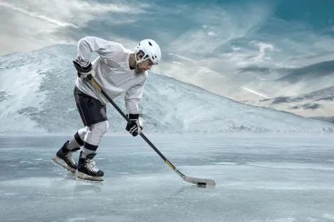 Ice hockey player on the ice in mountains Stock Photos