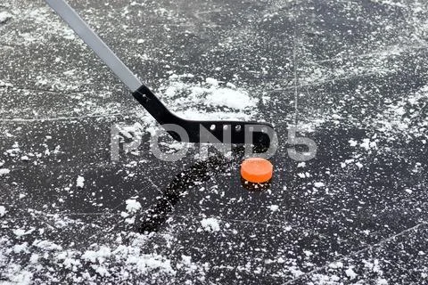 Ice Hockey Stick And Puck On Frozen Lake, Close-Up