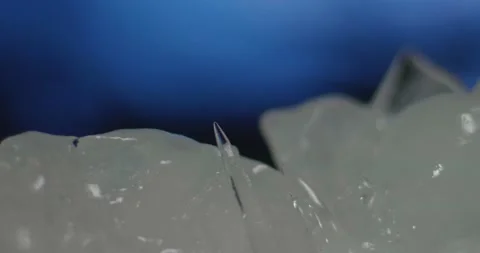 Ice icicle is growing on blue background. Ice melt time lapse Stock Footage 149688249