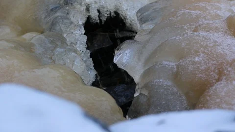 Ice in interesting shape surrounding running stream of water. Stock Footage 88982716
