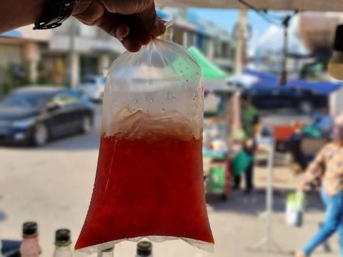 Ice lemon tea. A man's hand pick a drink is packed in a clear plastic bag. .. Foto stock