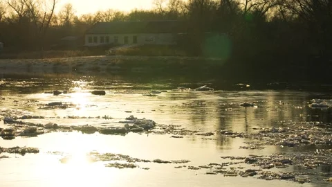 Ice melts river sunset current, glowing evening ripples, riverside sunset Stock Footage 278936585