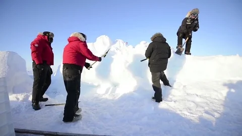 Ice mining in Arctic - Men chipping at ice mound Stock Footage 74775654