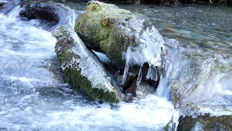 Ice over rock in cold mountain stream Video stock 70356238