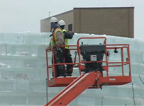 Ice Palace construction 2, hardhat workers high atop ice block walls Stock Footage 296343832