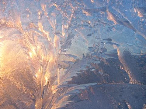 Ice pattern and sunlight close up on window glass early in the morning Stock Photos