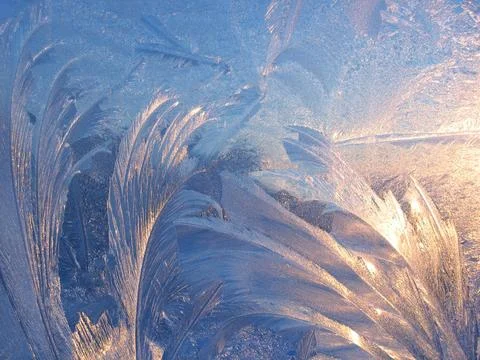 Ice pattern and sunlight close up on window glass early in the morning Stock Photos