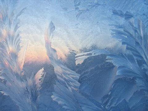 Ice pattern and sunlight on window glass early in the morning Stock Photos