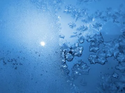 Ice pattern and sunlight on winter glass Stock Photos