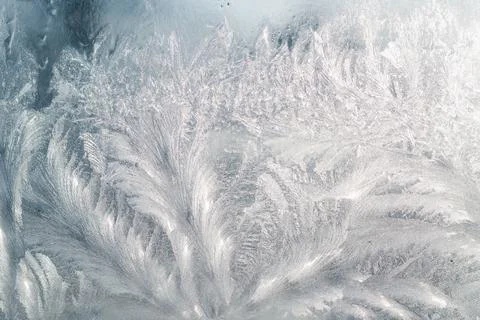 Ice pattern on a glass window in the backlight of the winter sun Stock Photos